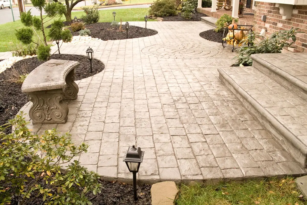 Crew finishing a large stamped concrete driveway at a Willow Park, TX residential home for added durability and style